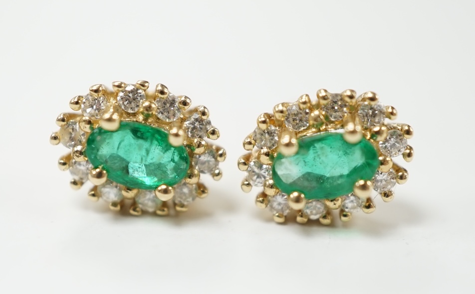 A modern pair of 14k, emerald and diamond set oval cluster ear studs, 8mm, gross weight 1.4 grams. Condition - fair